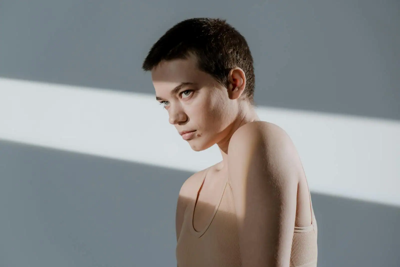 Portrait d'une femme aux cheveux courts coiffée d'un pixie texturé en lumière naturelle