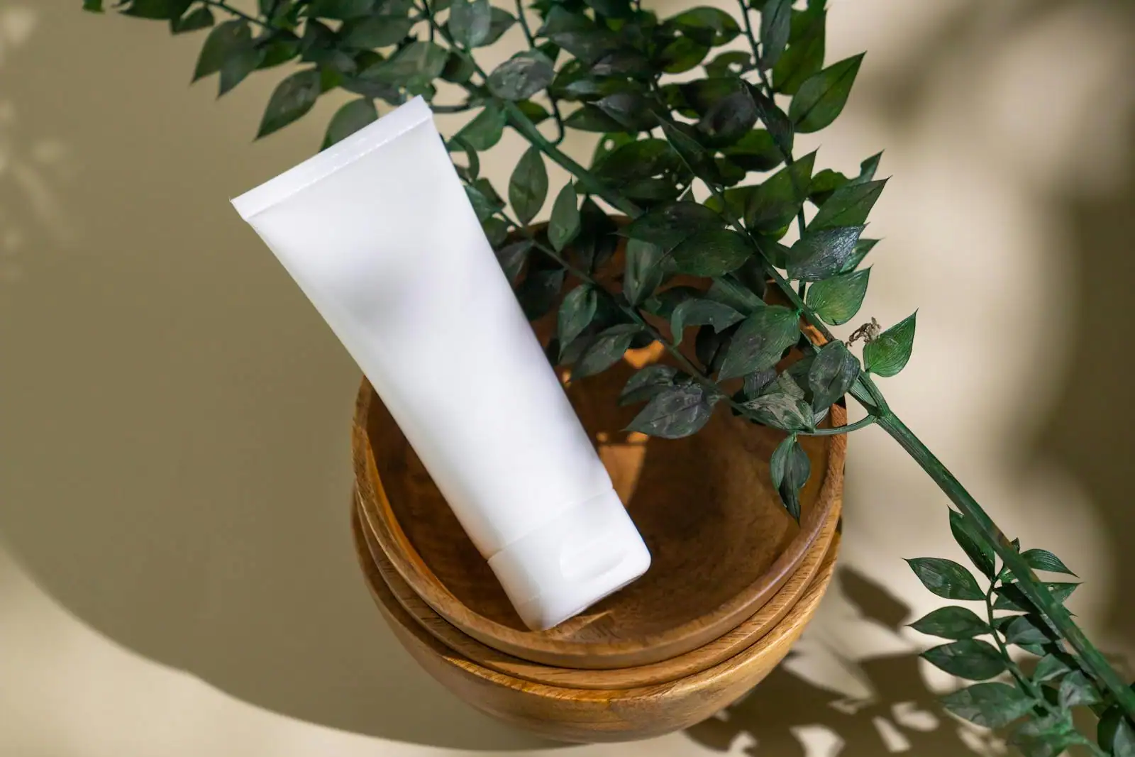 Tubes et palettes de maquillage bio en packaging carton et bambou disposés sur un tissu de lin clair