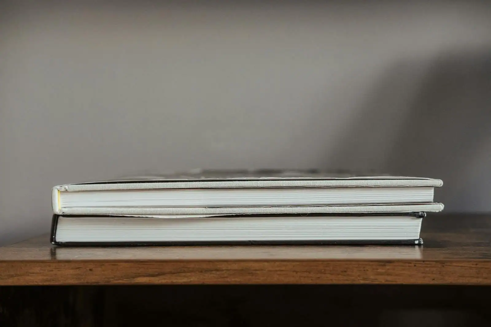 Pile de livres ouverts sur une table en bois, lumière naturelle d'après-midi.