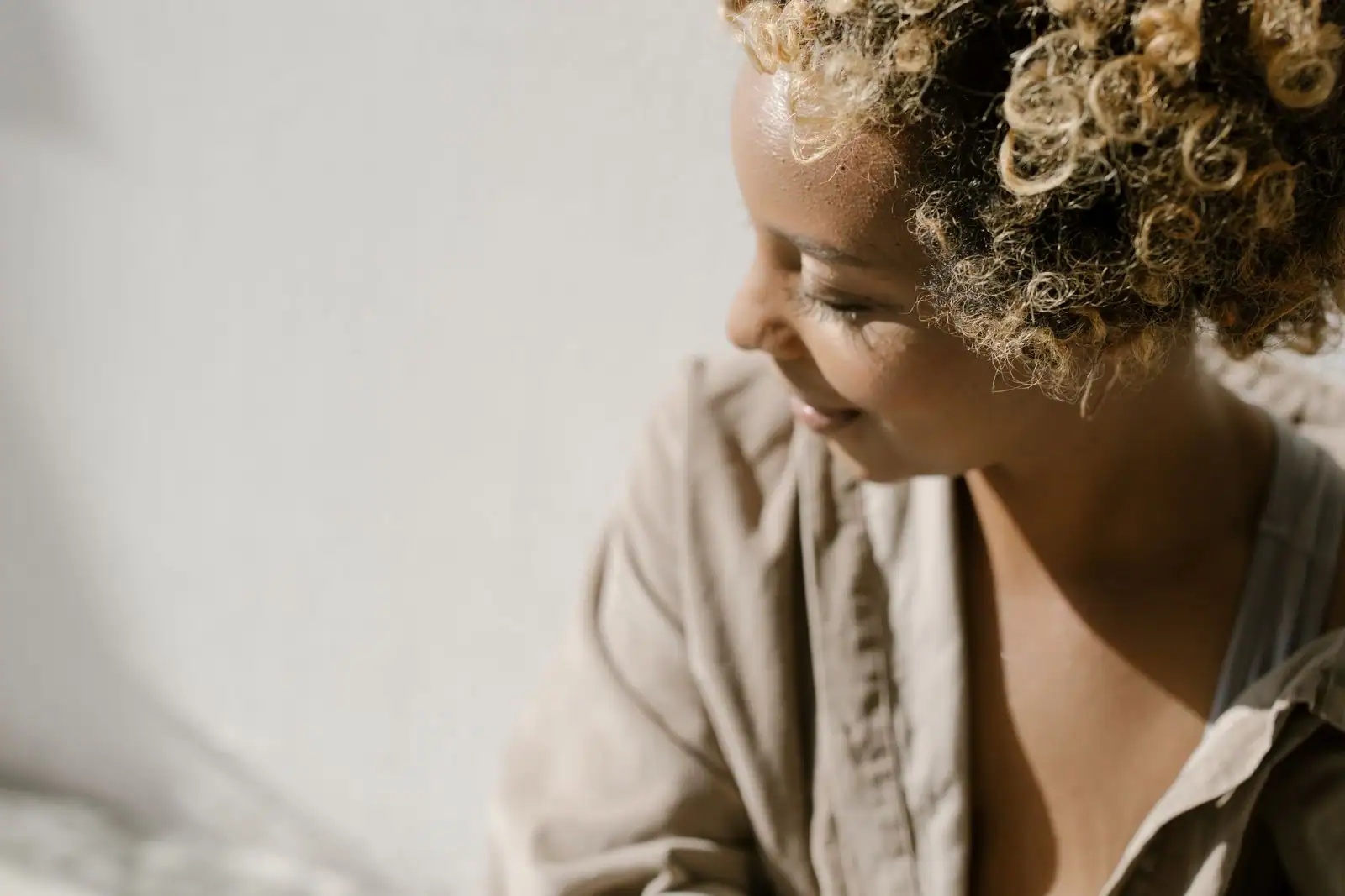 Cheveux bouclés foncés en gros plan, mèches définies, lumière naturelle douce.