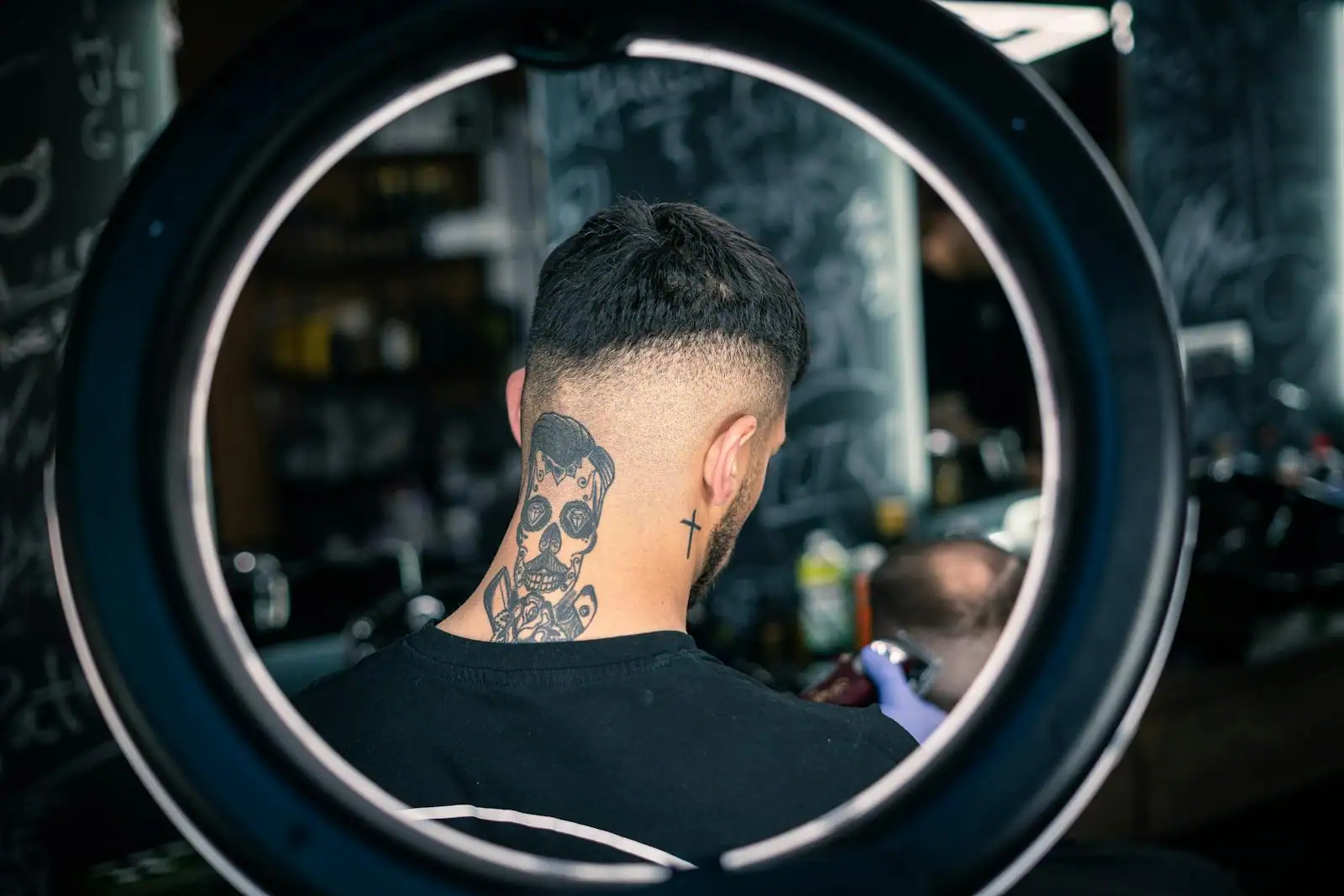 Vue de dos d'un homme aux cheveux dégradés nets sur les côtés et la nuque, dans un salon de coiffure