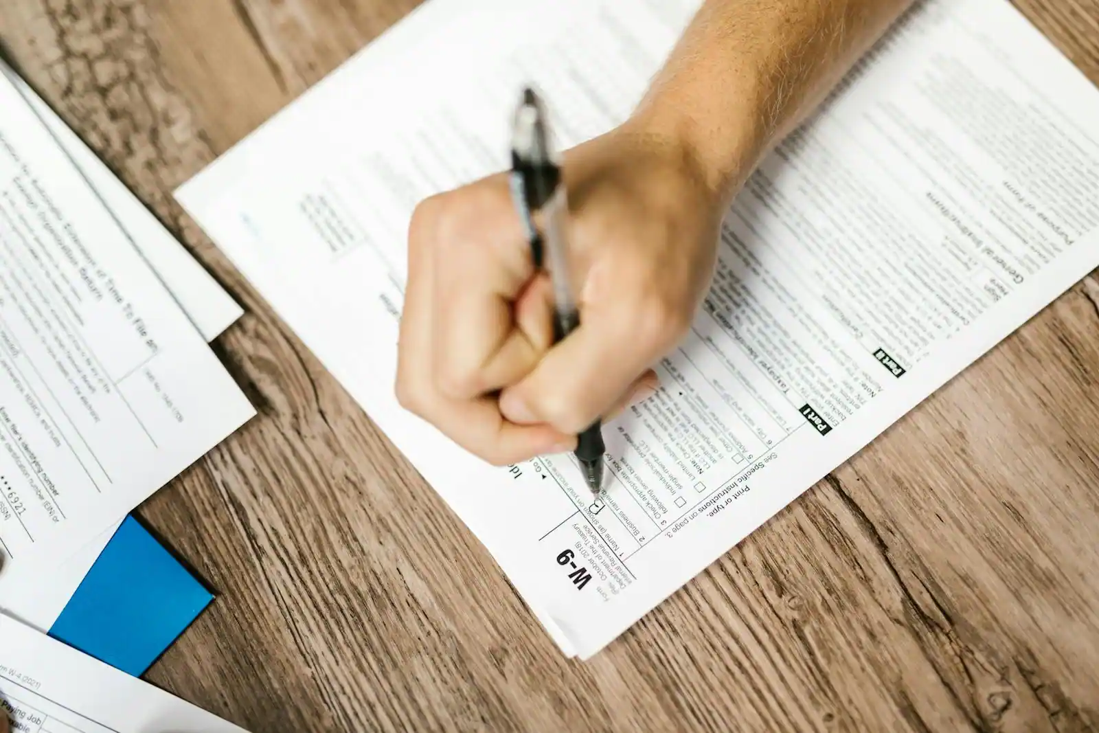 Personne remplissant un questionnaire papier avec un stylo, dans un moment de réflexion calme