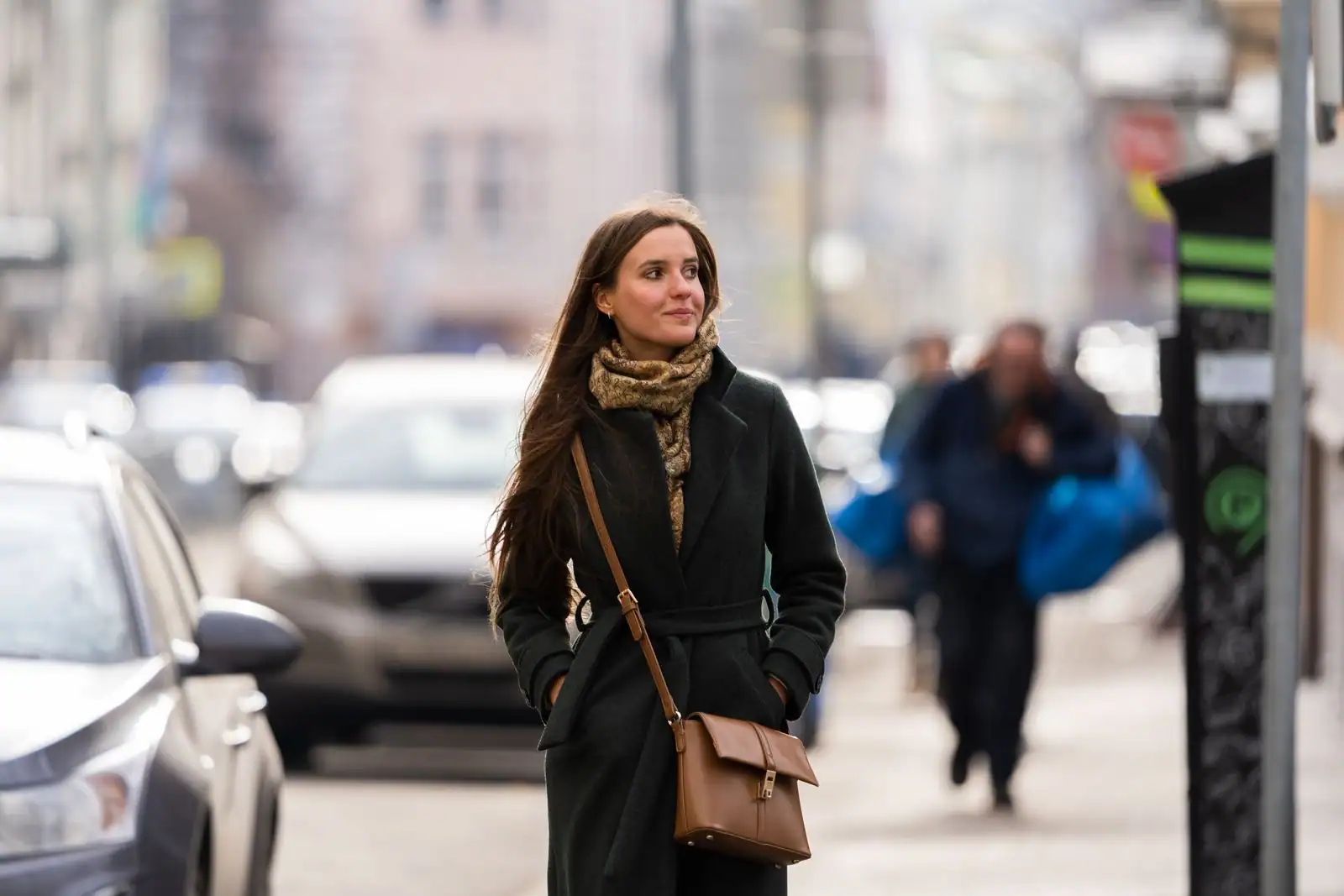 Femme élégante en tenue actuelle marchant en ville, allure mode du moment