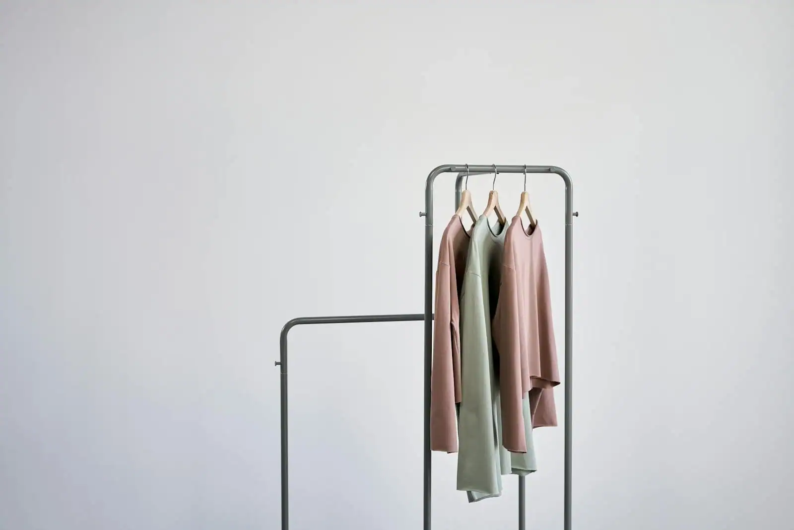 Portant de vêtements aux tons neutres et beiges dans une boutique lumineuse, sélection de pièces mode
