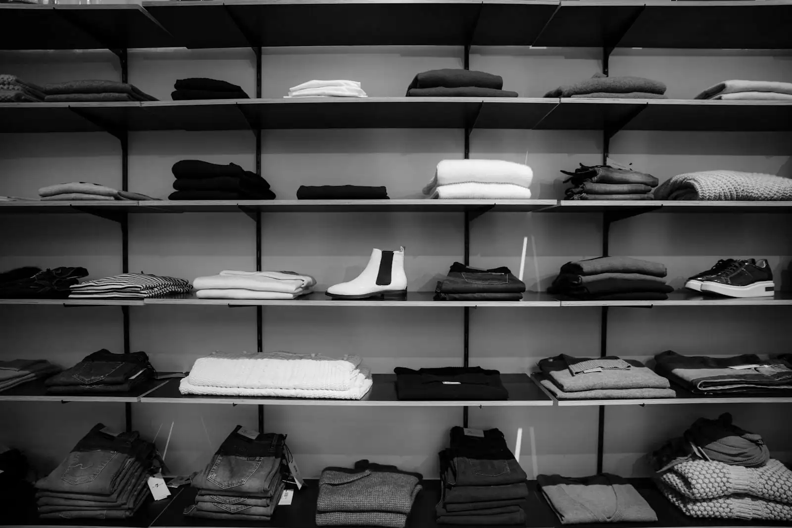 Des piles de vêtements pliés rangés sur les étagères d'un rayon textile.