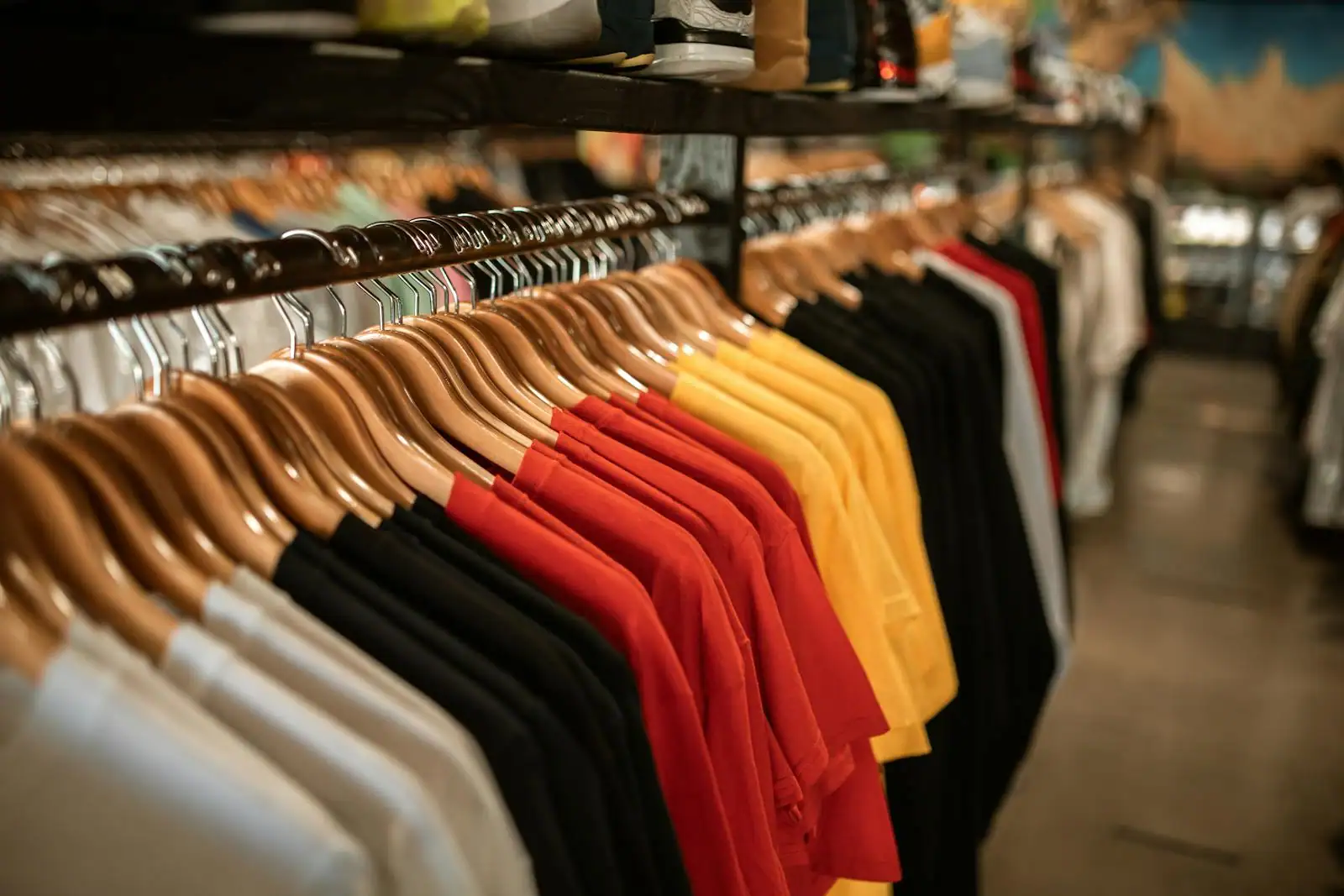 Portant de vêtements bien rangés dans une boutique de mode à la lumière naturelle