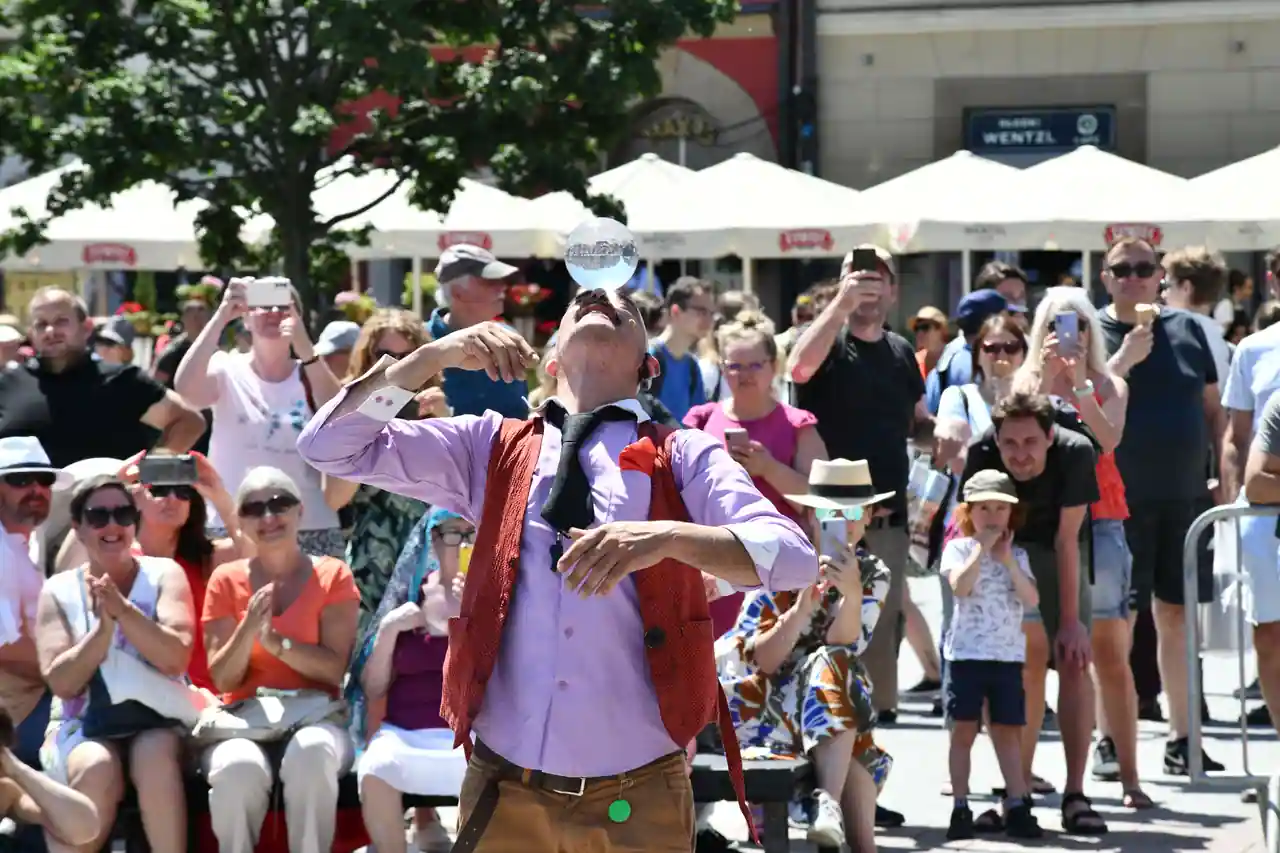 Spectacle de théâtre de rue joué en plein air devant un public rassemblé sur une place