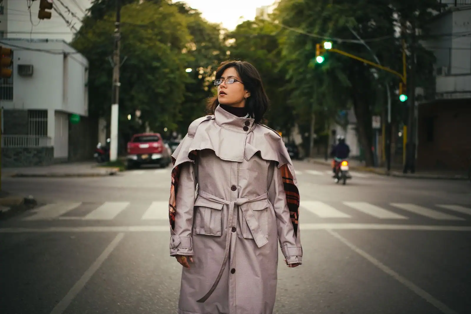 Femme en trench clair dans une rue, allure street style aux tons neutres de Fashion Week.