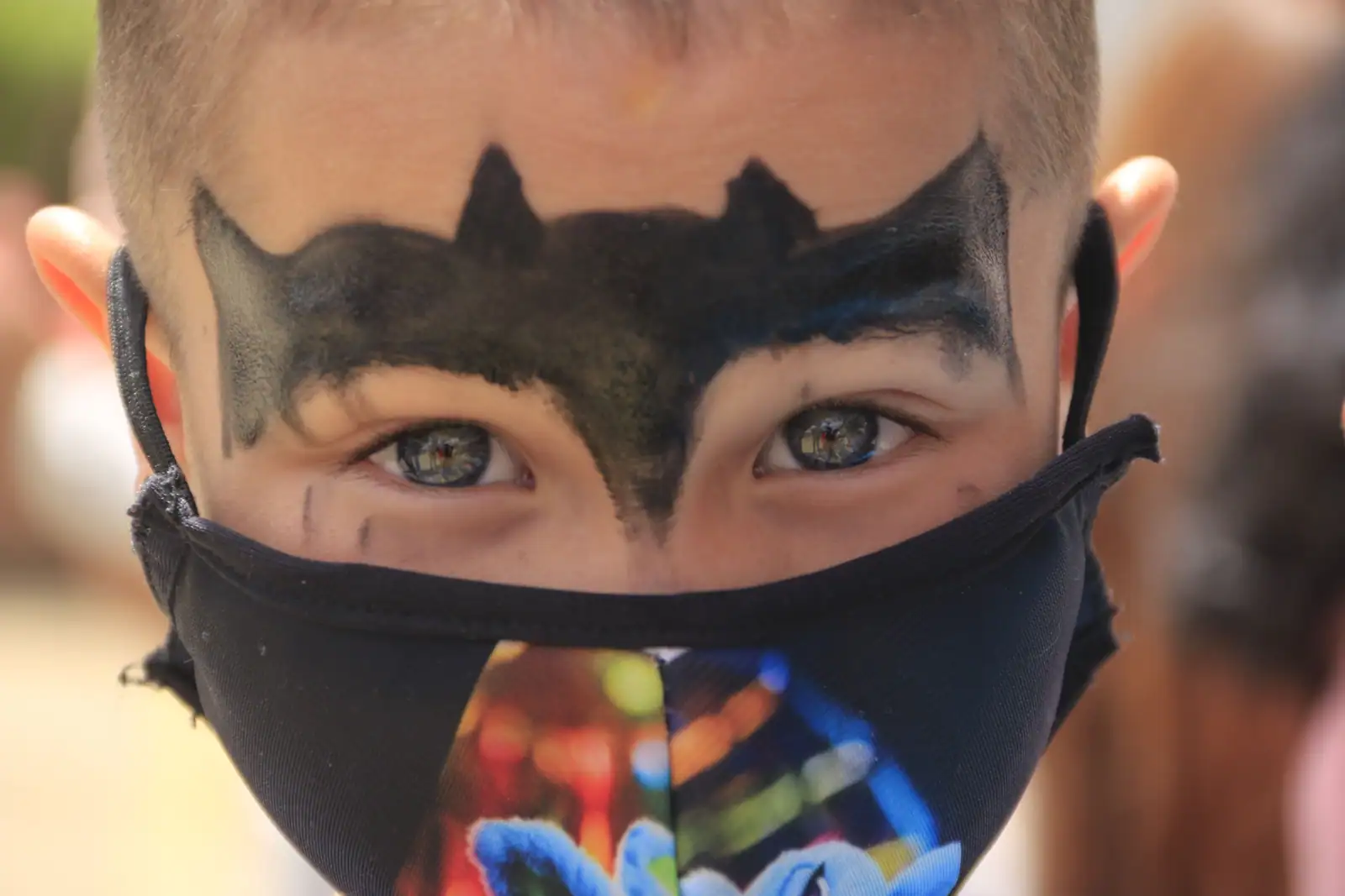 Enfant au visage peint en Batman, masque noir en forme de chauve-souris autour des yeux