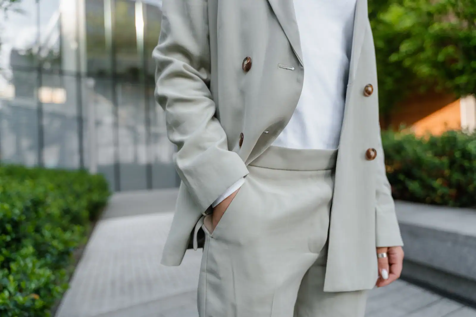 Un homme en blazer beige bien coupé, main dans la poche, illustrant une tenue masculine sobre et nette.