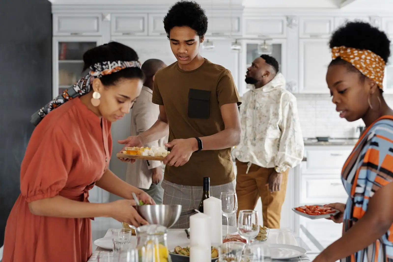 Famille réunie autour d'une table garnie pour un repas convivial, dans une ambiance chaleureuse