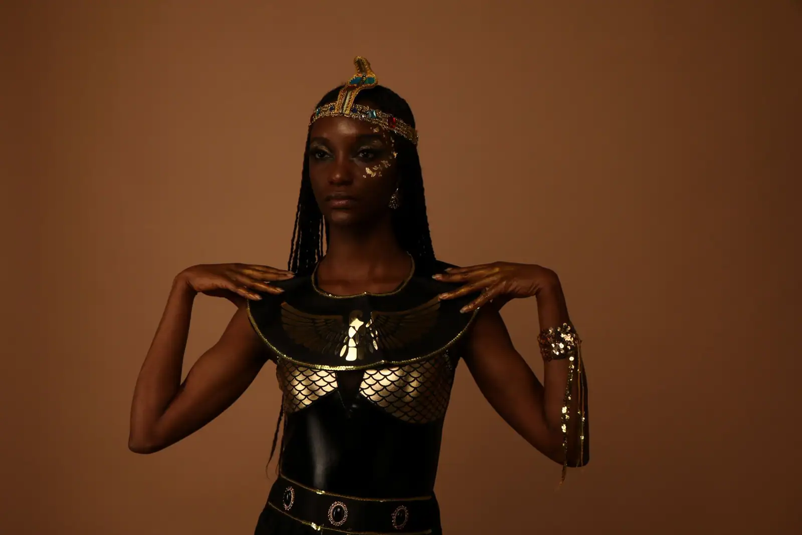 Femme en costume de Cléopâtre, coiffe à cobra doré et col égyptien, les yeux soulignés de noir