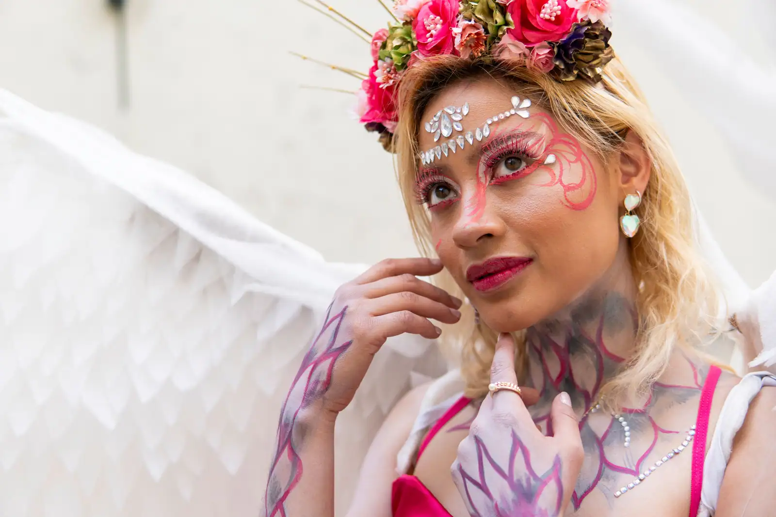 Maquillage de fée : arabesques roses remontant du coin de l'œil vers la tempe et strass sur le front