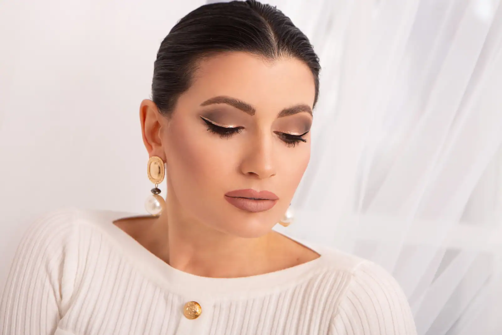 Un œil maquillé d'un smoky bronze estompé, sourcil dessiné et trait d'eye-liner allongé vers la tempe.