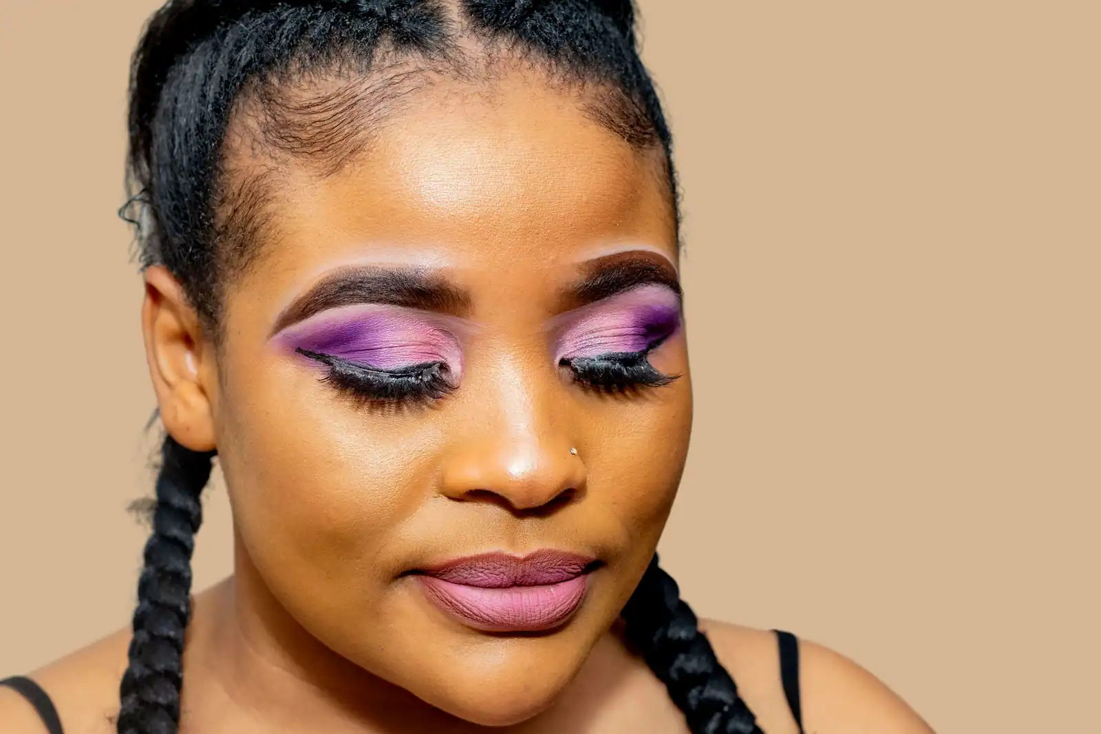 Paupières maquillées d'un dégradé violet remontant vers l'extérieur, soulignées d'un eyeliner noir net